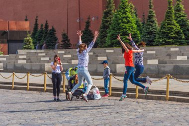 Rusya, Moskova, Kızıl Meydan, 22 Mayıs 2018 - Bir turistin kadınları resim çektirmek için zıplıyorlar