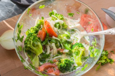 Karışık çiğ yumurta, brokoli, domates ve sebzeler cam bir kasede - omlet pişirme