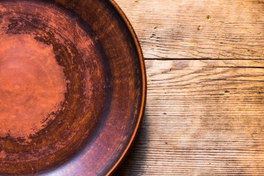 Eski ahşap bir masa üzerinde çatallı boş kil plaka, üst görünüm, kopyalama alanı, yakın çekim