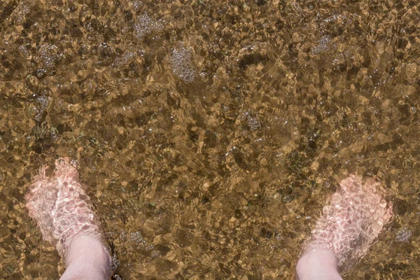 男人的脚在沙滩上的水里 — 图库照片