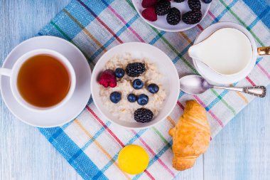 Organik vejetaryen kahvaltısı - çilekli yulaf ezmesi, süt, çay ve kruvasan