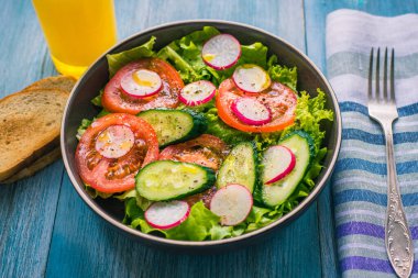 Vejetaryen kahvaltısı - salatalı, domatesli, salatalıklı, turplu ve portakal suylu diyet salatası.