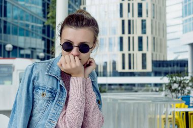 Kafede yuvarlak güneş gözlüklü hoş bir kadın.