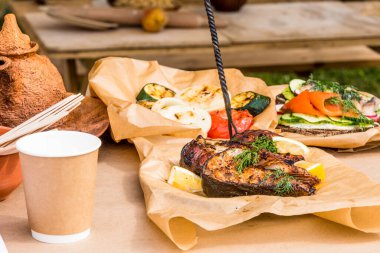 Kırsal bir arka planda ızgarada kızarmış balık ve sebze - dinlenme, açık havada piknik