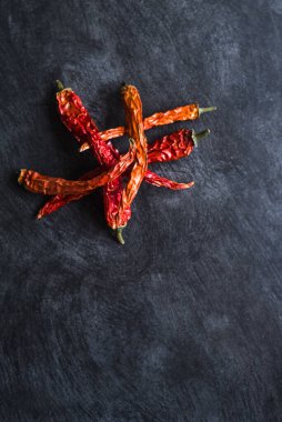 Siyah arka planda kurutulmuş kırmızı kırmızı kırmızı biber kabukları.