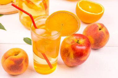 Elma, şeftali, limon ve portakal ve bardakta buzlu taze meyve suyu.