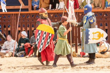 Rusya, Moskova, 8 Haziran 2019 şövalye turnuvasının yeniden inşası. Zırhlı iki savaşçı ve şövalye sancağında bir çocuk.