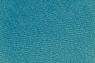 Güzel deniz arka planı - temiz deniz suyunda dalgalanmalar olan kumlu taban, üst manzara