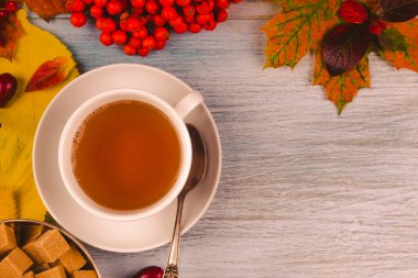 Kırsal ahşap arka planda sonbahar yaprakları ve böğürtlenli çay, boşluğu kopyala