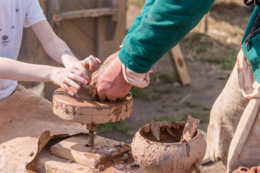 Erkeklerin ve çocukların elleri kilden bir fincan yapar. Geleneksel el sanatları öğretme kavramı.