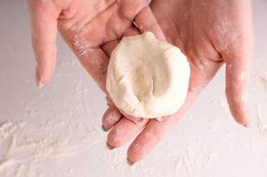 Bir parça hamur tutan kadın