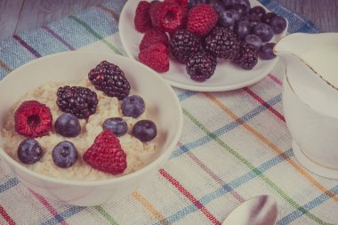 Çilekli yulaf lapası ve sade ahşap arka planda süt sağlıklı organik bir kahvaltı.