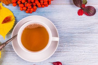 Kırsal ahşap arka planda sonbahar yaprakları ve böğürtlenli çay, boşluğu kopyala