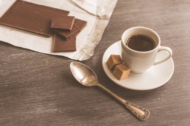 Masada bir fincan kahve ve çikolata.