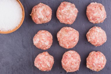 Tahtada çiğ köfteler, koyu arkaplan, üst görünüm - bir tarif için kopyalama alanı