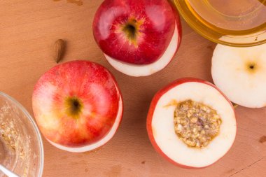 Elmalar tencerede, bal ve fındıklar tahtanın üzerinde