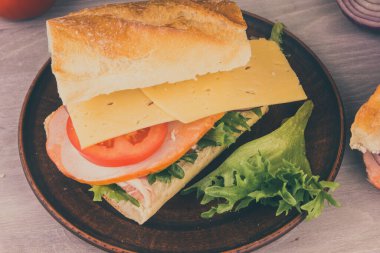 Jambonlu, peynirli, marullu, soğanlı ve domatesli taze sandviç.