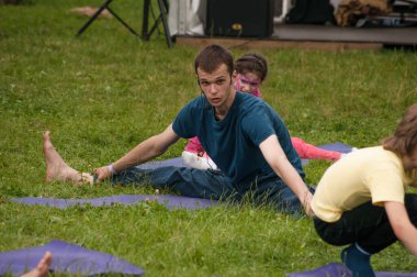 Rusya, Moskova 16 Haziran 2012, Garden Hermitage, Gıda Festivali - Parktaki çimlerde yoga yapan insanlar