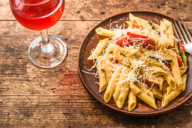 Klasik İtalyan makarnası, kabaklı ve domatesli. Kırsal bir masada kil tarakta. Üst manzara, bir tarif için kopyalama alanı.