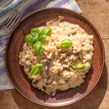 Geleneksel İtalyan yemeği. Mantarlı risotto. Fesleğen yapraklı.