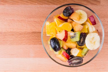 Tahtadaki cam bardakta meyve salatası. Kapatın, kopyalayın. Sağlıklı yaşam tarzı kavramı.