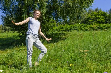 Genç çekici kadın güneşli bir günde dışarıda yoga yapmayı öğreniyor.