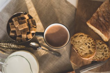 Sabahın erken saatlerinde bir kupa sıcak çikolata, süt ve ekmek.