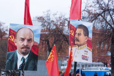 Moskova, Rusya, 7 Kasım 2017 - Lenin ve Stalin 'in portreleriyle Ekim Devrimi onuruna düzenlenen törende insanlar