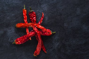 Koyu bir arkaplanda kırmızı biber kabukları. Yakın çekim, boşluk kopyalama.