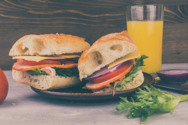 Jambonlu, peynirli, marullu, soğanlı ve domatesli sandviç.