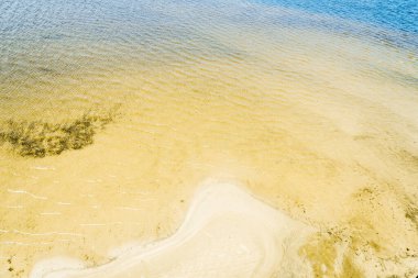 Deniz koyunun kumlu kıyısı, yakın plan.