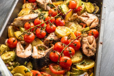 Sebzeli rosto ve kabaklı balık parçaları - kabaklı, dallı vişneli domates, patates, soğan, üst görünüm