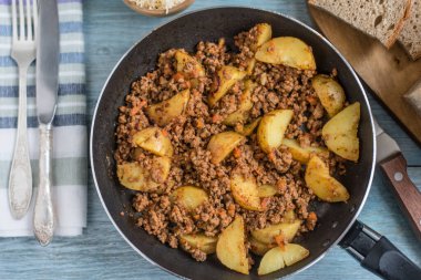 Kızartma tavasında tuzlu kıyma ve patates parçaları - rustik yemek