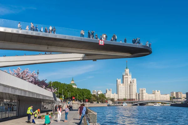 Moskova, Rusya, 7 Mayıs 2018 - Moskova nehri üzerindeki yaya köprüsü, Zaryadye Parkı ve Kotlenicheskaya Embankment üzerinde bir gökdelen.