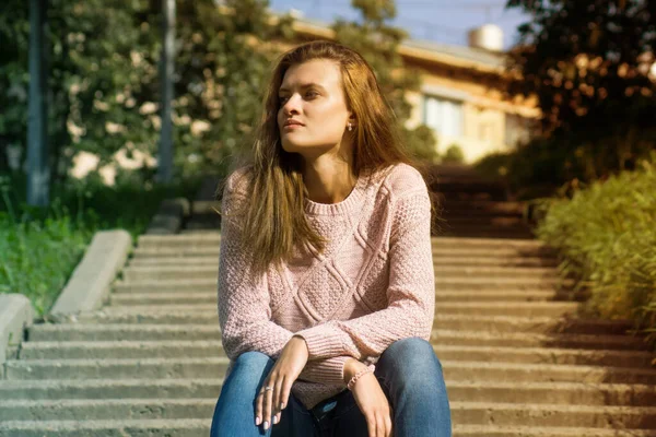 公園の階段に座って長い髪の美しい若い女性 — ストック写真