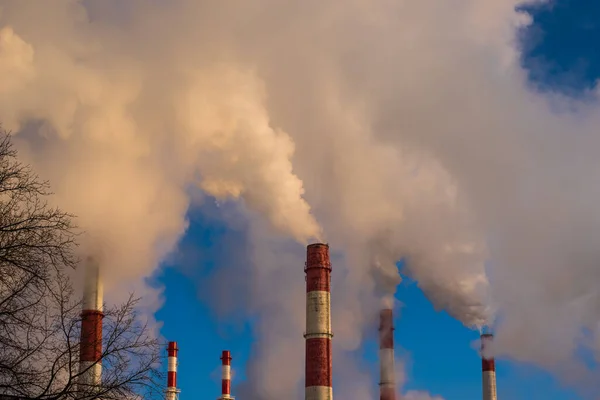 industrial smoke from chimneys on blue sky