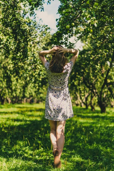 Genç ve çekici bir kadın bahçede saçını düzeltiyor.