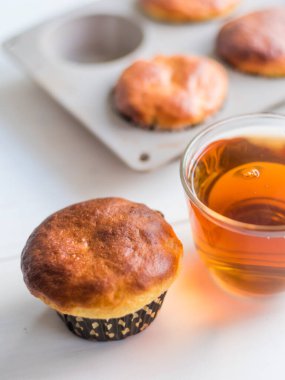 Taze ev yapımı kekler ve pencere kenarındaki masada bir fincan sabah çayı.
