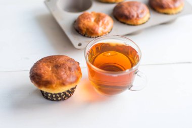 Taze ev yapımı kekler ve pencere kenarındaki masada bir fincan sabah çayı.