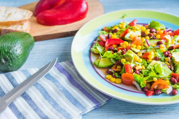 Avokado, fasulye, mısır, soğan, marul ve domatesli Amerikan-Meksika salatası.