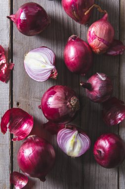 Eski bir ahşap masanın üzerinde yatan kırmızı soğan ampuller.