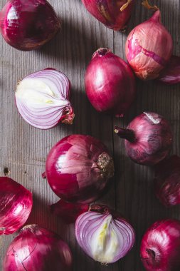 Eski bir ahşap masanın üzerinde yatan kırmızı soğan ampuller.