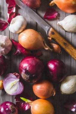 Eski bir ahşap masanın üzerinde yatan farklı soğan ampuller birkaç tür.
