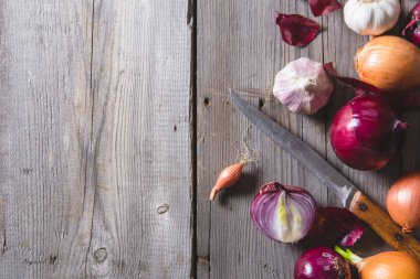 Eski bir ahşap masanın üzerinde yatan farklı soğan ampuller birkaç tür.