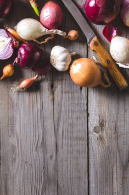 Eski bir ahşap masanın üzerinde yatan farklı soğan ampuller birkaç tür.
