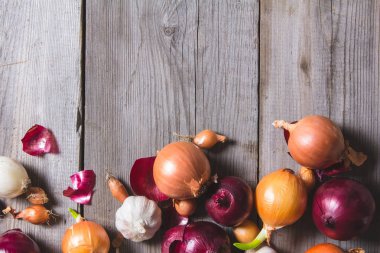 Eski bir ahşap masanın üzerinde yatan farklı soğan ampuller birkaç tür.