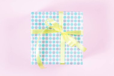 Hediye kutusu ile sarı şerit pembe bir arka plan üzerinde