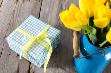 Vazo ve giftbox ahşap bir zemin üzerine Sarı laleler buket