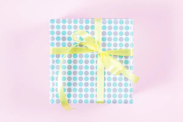 Caja de regalo con cinta amarilla sobre fondo rosa —  Fotos de Stock