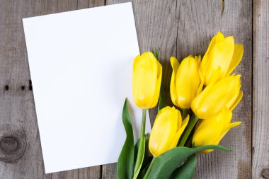 Buket Sarı laleler ve hediye kutusu gri ahşap zemin üzerine